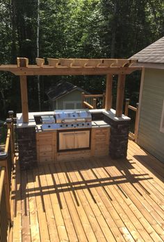 an outdoor bbq and grill on a wooden deck