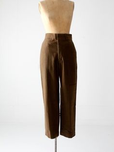 A pair of vintage American army wool pants circa 1940s-1950s. With a high-waist and full straight leg, the wool trousers have a clean, classic style. The tone of the fine wool is an olive brown. The pants feature a button fly, suspender buttons on the inside waistband, and 5 pockets.  CONDITION In good condition with wear consistent with age and use. There is a rust tone line mark on the front left leg. There are very small moth bites (not full holes) on the front of the right leg.  MEASURED SIZE:  30 x 31 MEASUREMENTS Waist: 15" (30)  ...  38.1 cm (76.2) Inseam: 31"  ...   78.7 cm Rise: 12.5" ...  31.8 cm Hips: 21.5" (43) ...  54.6 cm (109.2) HOW WE MEASURE → Pants measured lying flat. → Waist measured across the bottom seam of the waistband.  → Inseam measured up the inside of the legs. Gifts For Women Over 50, Army Pants, Fashion For Petite Women, Womens Tops Dressy, Outfits Petite, Pants Women Fashion, Office Fashion Women, Wool Trousers, Women Over 50