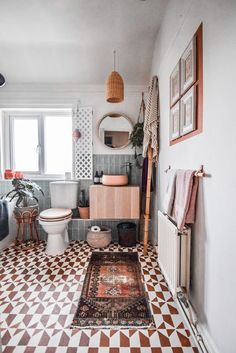 a bathroom with a rug, toilet and sink in it's centerpieces