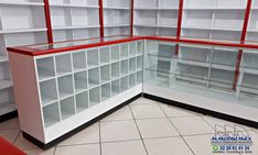 an empty white and red display case in a room with tile flooring on the ground