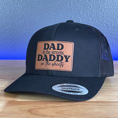 Dad In The Streets Daddy In The Sheets Rectangular Leather Patch Hat Black/Black Specifications: 🧢 SnapBack Trucker Hat; adjustable for the perfect fit 🎩 Cotton/polyester blend for comfort 📏 One size fits most 🏷️ Expertly laser engraved leatherette patch design 📦 Ships in 2 to 3 business days from our Orlando Studio Care Instructions: 🚫 Do not wash; spot clean only Please Note: 🌈 Colors may vary from photos based on your viewing screen. Adjustable 5-panel Dad Hat With Logo Patch, Trucker Hat With Leather Patch, Six-panel, Black Six-panel Snapback Hat With Leather Patch, Orlando Studios, Adjustable 5-panel Trucker Hat With Leather Patch, Black Hats With Logo Patch, One Size, Leather Patch Hat, Engraved Tumblers, Patch Hat