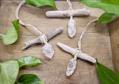 three pieces of driftwood are tied together with twine and some leaves on the table