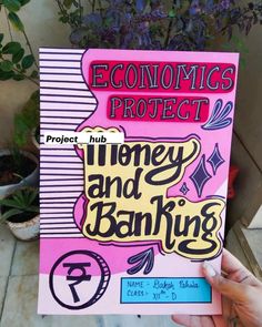 a person holding up a pink book with the words'economic project money and banking '