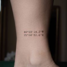 a woman's foot with the coordinates tattooed on her left side, and numbers written in black ink