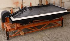 a large black and white object sitting on top of a wooden table next to a wall