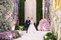 a bride and groom are walking down the aisle at their wedding ceremony in front of flowers