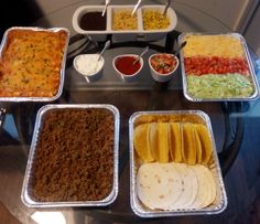 several trays filled with different types of food on top of a glass table next to each other