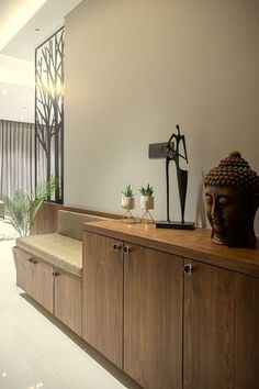 a room that has some wooden cabinets and plants on the top shelf in front of it