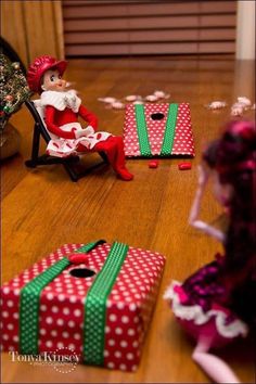 an elf sitting on a chair next to presents