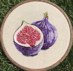 a cross stitched picture of two figs on some grass