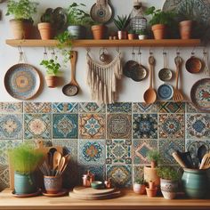 many pots and pans are hanging on the wall above a counter with potted plants