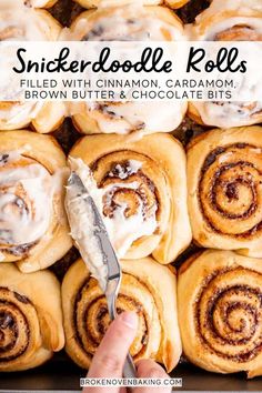 cinnamon roll rolls with cream cheese frosting in a baking pan being held by a hand