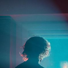 a person standing in front of a mirror with their back turned to the camera and light shining on them