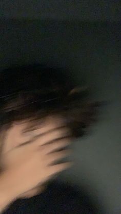 blurry image of a woman's face with her hair blowing in the wind