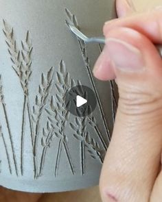 someone is using a sharp knife to cut out the design on a vase's base