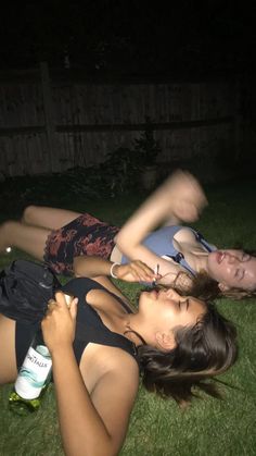 two young women laying on the grass at night