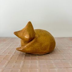 a small ceramic animal sitting on top of a tile floor