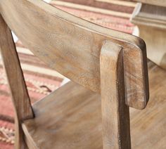 a wooden chair sitting on top of a rug