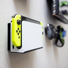 a yellow nintendo wii game controller mounted to the side of a wall next to other items