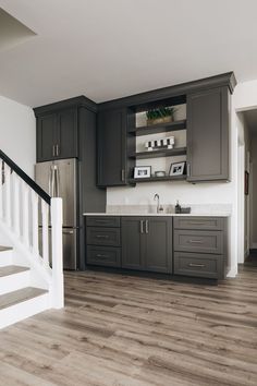 a kitchen with gray cabinets and white stairs