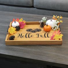 a wooden tray with pumpkins and pine cones on it that says, hello fall