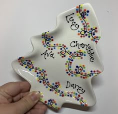 a hand holding a ceramic plate with words on it