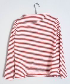 a red and white striped shirt hanging on a hanger, with the top half turned down