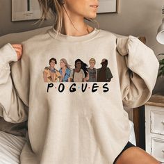 a woman wearing a sweatshirt with the word poggies printed on it in front of her