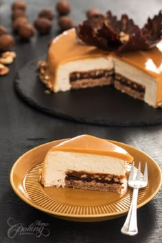 a piece of cake on a plate with a fork next to it and some nuts in the background