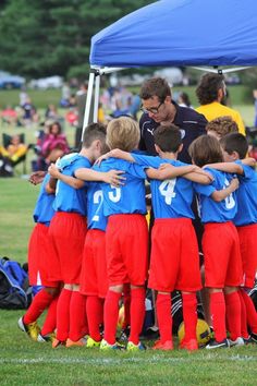 a soccer team huddles together in front of a tent at the end of a game