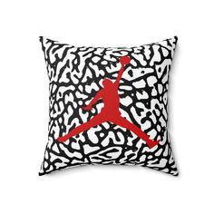 a black and white pillow with a red jordan logo on the front, in an animal print pattern