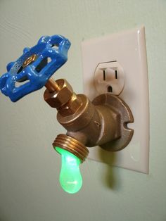 a light switch with a green light on it and an electrical outlet attached to the wall