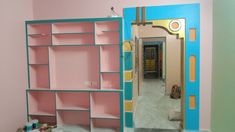 the room is painted pink, blue and yellow with an open door to another room