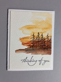 a card with the words thinking of you written on it and trees in the background