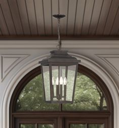 a lantern hanging from the ceiling in front of an open door with three lights on it