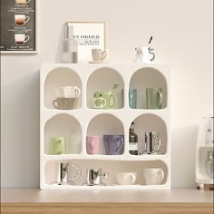 a shelf filled with cups and mugs on top of a wooden table