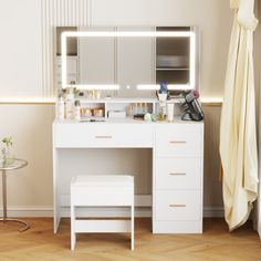 a white vanity with lighted mirror and stool next to it on a wooden floor in front of a window