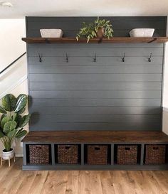 an entryway bench with baskets and plants on it