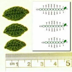 three green crocheted leaves are shown next to a ruler and measuring tape with the same pattern on it