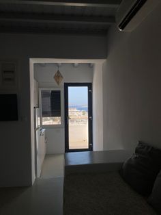 an empty room with a door leading to another room and a view of the beach