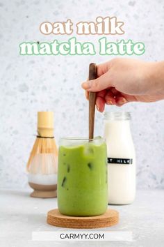 a hand holding a wooden spoon over a green smoothie in a glass with the words oat milk matcha latte