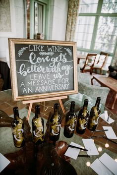 there is a sign on the table with wine bottles