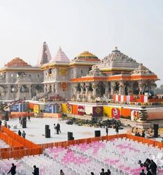 many chairs are set up in front of an elaborately decorated building with orange and yellow accents