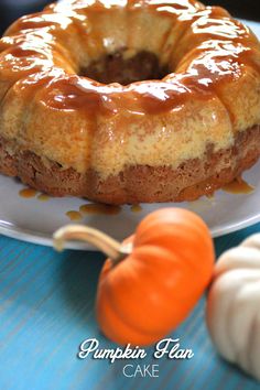 a bundt cake sitting on top of a white plate next to mini pumpkins