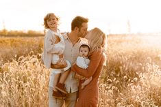 a man, woman and child posing for a photo in the middle of a field