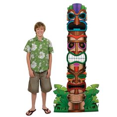 a boy standing in front of a totem pole