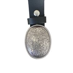 An engraved metal belt buckle with a floral design pulls a great outfit together. A stylish country western buckle really makes a statement and looks great with a pair of jeans and boots. The oval buckle with rope and floral design fits on a belt with a width up to 1 1/2 inches wide.   The buckle dimensions are 3 1/8 x 2 3/8  Fits a belt width up to 1 1/2 inches or 38 mm wide. The belt is not included but may be purchased for an additional cost. All buckles are packaged in organza gift bags for Formal Adjustable Concho Belt, Adjustable Concho Belt Buckles For Western-themed Events, Adjustable Engraved Belt Buckles For Western-themed Events, Engraved Adjustable Western Belt Buckles, Engraved Adjustable Belt Buckles For Rodeo, Adjustable Engraved Belt Buckles For Rodeo, Formal Adjustable Engraved Belt, Adjustable Silver Belt Buckles For Western-themed Events, Silver Belt Buckles For Rodeo