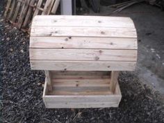 a wooden bench sitting on top of gravel next to a pile of wood planks