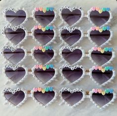 heart shaped sunglasses are arranged on a marble surface