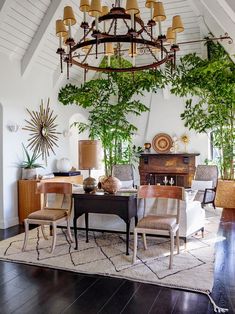 a dining room table with chairs and a chandelier hanging from it's ceiling